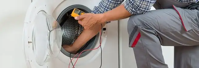 Dryer repair technician inspecting and repairing a clothes dryer in Providence, RI