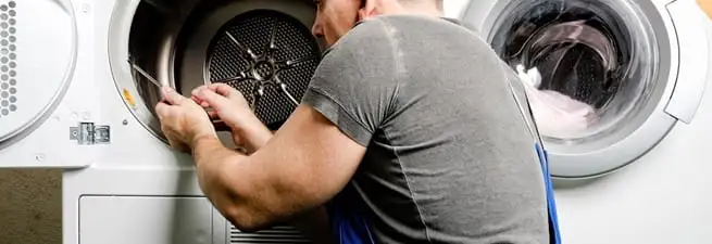 Dryer repair technician fixing a clothes dryer drum in Providence, RI