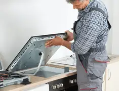 Appliance repair technician installing a built-in cooktop in Providence, RI