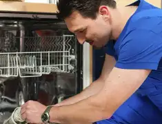 Dishwasher repair technician inspecting and servicing an open dishwasher in Providence, RI