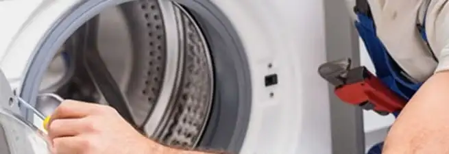 Appliance technician repairing a clothes dryer drum and internal parts in Providence, RI