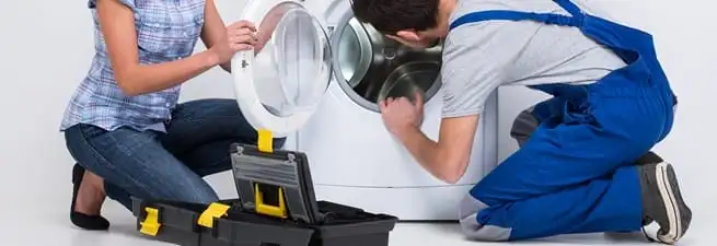 Washer repair technician inspecting a front-load washing machine with tools in Providence, RI