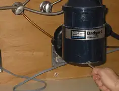 Garbage disposal repair technician tightening the mounting ring under a sink in Providence, RI