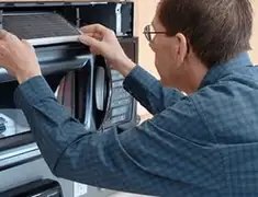 Appliance repair technician replacing a microwave vent filter in Providence, RI