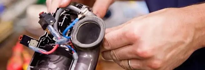 Vacuum repair technician reconnecting wiring and components in Providence, RI