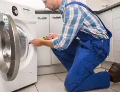 Washing machine repair technician servicing a front-load washer in Providence, RI