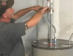 Water heater repair technician tightening supply line connections in Providence, RI
